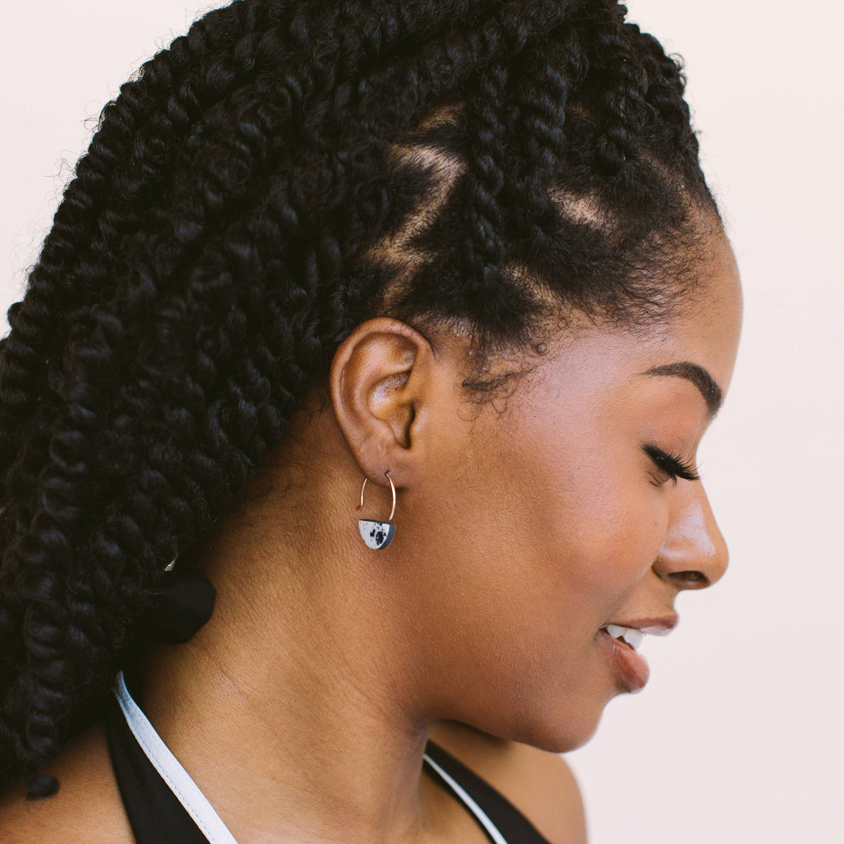 Woman with styled hair on a plain background wearing porcelain earrings