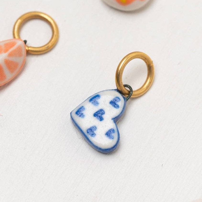 Colorful ceramic blue and white heart charm on a white background