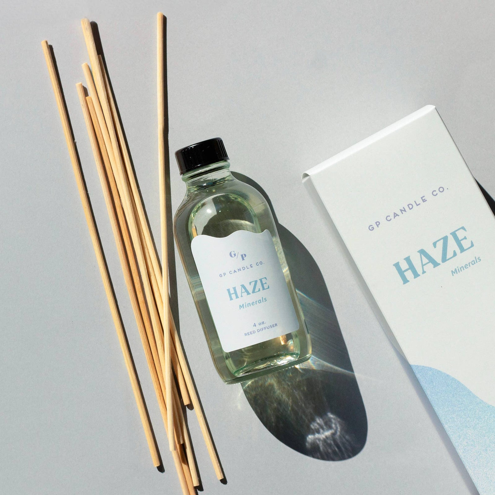 Handmade Haze Minerals reed diffuser with clear glass bottle, natural wooden reeds, and elegant white box gift packaging. - Haze Minerals Reed Diffuser