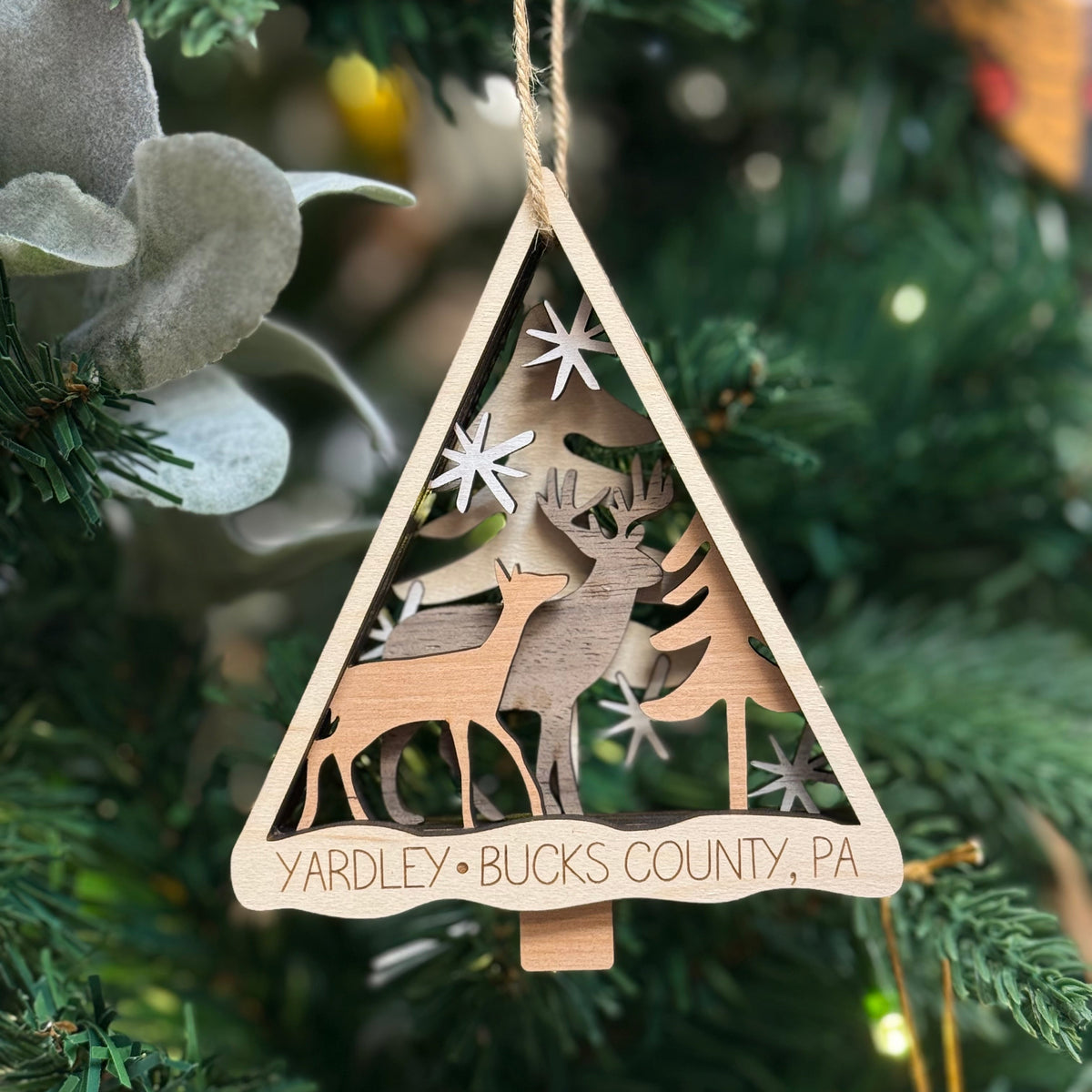 Yardley Bucks county wooden ornament with reindeer design hanging on a Christmas tree