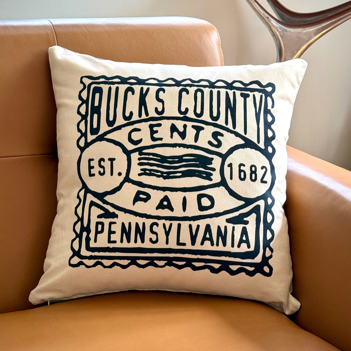 Decorative pillow with 'Bucks County, Pennsylvania' text on a brown couch.