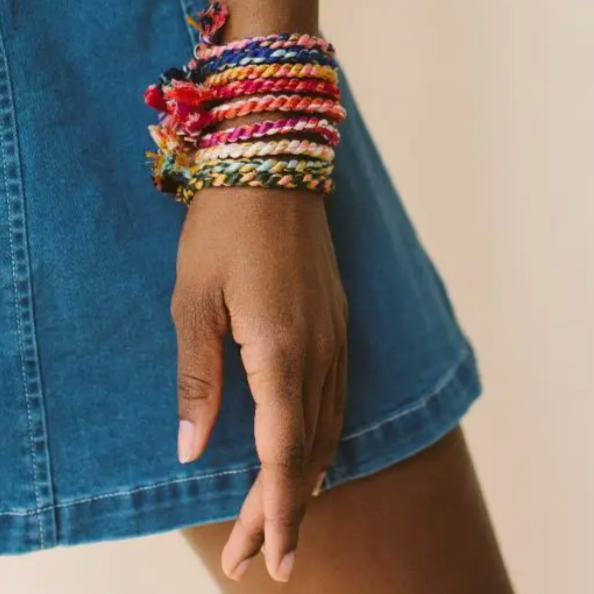 Stack of colorful handmade hand spun rope bracelets featuring vibrant red, pink, blue, and green tones, perfect artisan gift. - Hand Spun Rope Bracelet