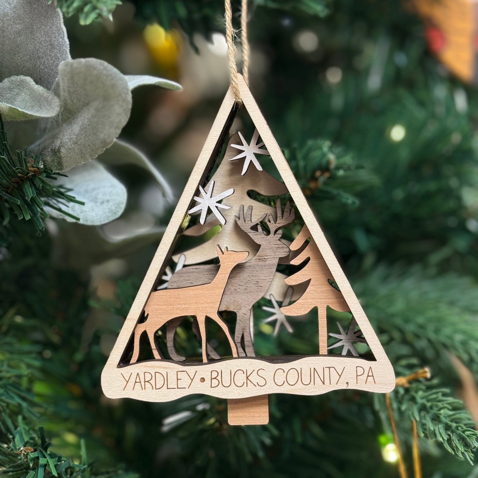 Yardley Bucks county wooden ornament with reindeer design hanging on a Christmas tree 