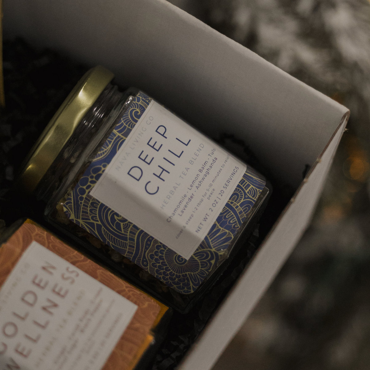 Two jars labeled 'Deep Chill' and 'Golden Wellness' in a box with a blurred background.